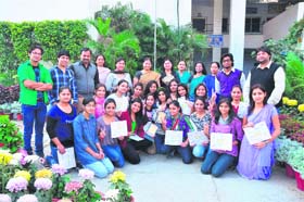 A group photo of prize-winning students of the college with the principal and other staff members