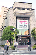 Cyclists pass before the Tokyo Stock Exchange building in Tokyo. Japan's two main bourses on announced plans on Tuesday to merge their operations in January 2013 as they look to boost competitiveness and create one of the world's biggest exchanges