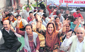 Members of the Home Guards Welfare Association stage a protest in support of their demands in Jammu on Tuesday