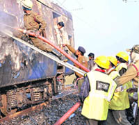 Firemen douse the fire that engulfed the Howrah-Dehradun Express on Tuesday