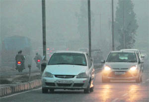 The practice of burning garbage along roadsides forces persons driving to switch on the lights of their vehicles on the Ambala-Chandigarh highway at Dera Bassi around 5 pm on Wednesday.