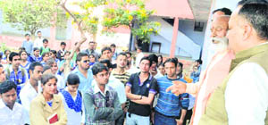 Students of SMJN College are pacified by the college management committee chief, Swami Ramanand Puri, in Haridwar on Wednesday
