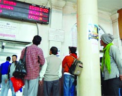 Passengers look at the electronic display board to find out the timings of arrival of trains at the Amritsar railway station on Thursday