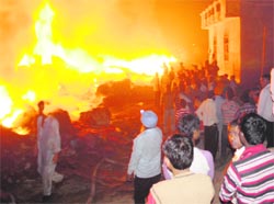 Firemen douse flames at a plastic waste godown in Gulmarg Avenue, Amritsar