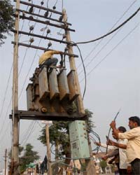 Employees of the electricity department install a transformer in Bathinda