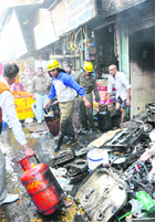 Fire brigade personnel take out LPG cylinders from an illegal godown and refilling centre in Karnal on Thursday