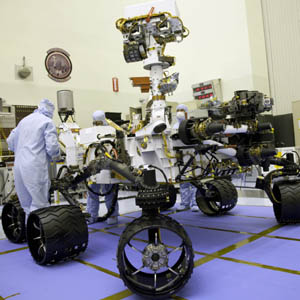Technicians look over the Mars Science Laboratory (MSL) Curiosity rover during inspections at the Jet Propulsion Laboratory in Pasadena, California, in this undated handout photo courtesy of NASA