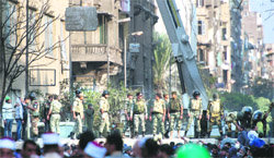 Security personnel erect a concrete barrier to separate the police and protesters just off Tahrir Square