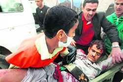 A wounded Yemeni pro-reform protester is rushed to a makeshift hospital in Sanaa's landmark Change Square