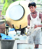 A child labourer washes utensils at a dhaba along the roadside in Jalandhar.