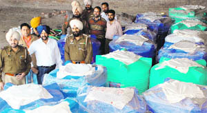 Police officials with the illicit liquor seized in Amritsar on Saturday. 