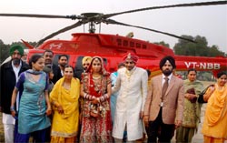 The couple, Manjeet Singh Sidhu and Namanpreet Kaur, flanked by their relatives at the Thermal Colony ground in Bathinda on Saturday. Seen in the background is the chopper in which the couple reached Bathinda from Malout