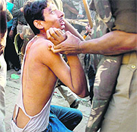 A cop arrests a Samajwadi Party worker who was protesting during AICC general secretary Rahul Gandhis rally in Padrauna on Saturday.