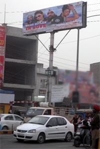 A movie poster dons the reverse side of a signboard at the Mall road
