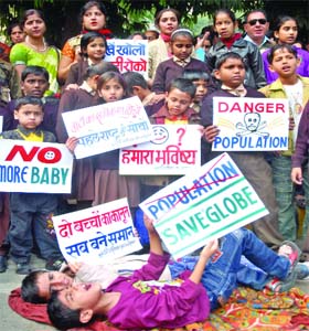 Schoolchildren take part in a demonstration against population increase at Jantar Mantar in New Delhi on Sunday