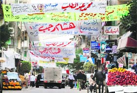 POLL TIME: People walk past banners ahead of the parliamentary elections due on Monday, in Alexandria on Sunday