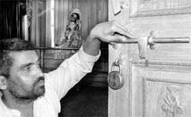 A priest shows the broken lock at the door