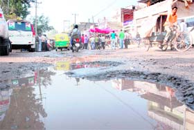 A puddle reflects the poor shape roads at Subhash Nagar, Mani Majra