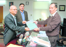 Uttarakhand Chief Secretary Subhash Kumar (right) is given a cheque for Rs 100 crore by Chief Managing Director of the Tehri Hydroelectric Development Corporation RST Sai in Dehradun on Monday.