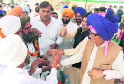 Chief Minister Bhupinder Singh Hooda (wearing a blue and pink turban) seeks votes for his candidate, Jarnail Singh, in Ratia