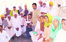 Labourers sit outside the office of Kaithal Deputy Commissioner. 