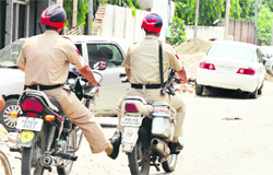 A policeman on a motorcycle assists his colleague after the latter's bike developed a snag in Jalandhar.