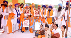 NRI Gurvinder Singh Brar (fourth from left and wearing a blue dotted scarf), Sukhpal Singh and Ranjit Singh Bhau being honoured at Bhuchho Khurd village.
