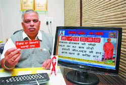 Narinder Kumar Bassi showing bookmark and AIDS awareness poster to be released on December 1 on the World AIDS Day in Bathinda