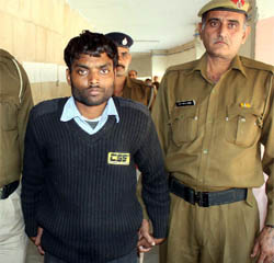 Security guard of the Axis Bank ATM, who has been accused of stealing money from the ATM, in police custody at Gurgaon. 