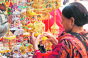 A woman buys decorative items from a shop at the main market in Katra.