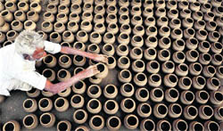 A potter arranges earthen pots before baking them in Ludhiana.