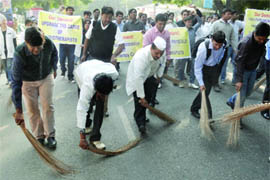 Members of the Indian Association of Physiotherapists sweep the street at Jantar Mantar in protest on Wednesday. 