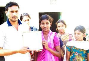 Manak's relatives with his photograph at his ancestral village Jalal