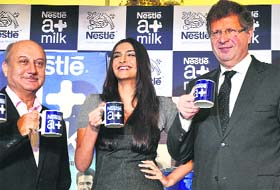 Bollywood actors Anupam Kher and Sonam Kapoor along with A. Helio Wasszyk, CMD of Nestle, at the launch of high quality milk in New Delhi on Thursday