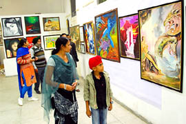 Visitors see the paintings put on display at the 17th Art Festival that started at the Teachers Home in Bathinda on Thursday. 