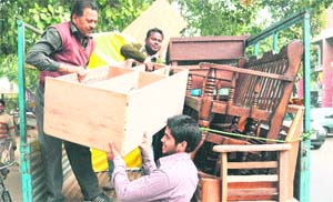 Members of the municipal corporation enforcement wing load furniture onto a truck during an anti-encroachment drive at the furniture market, Sector 34, Chandigarh, on Thursday.