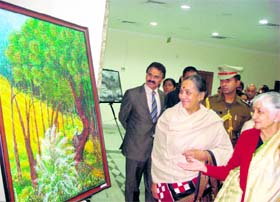 Monica Talukdar (right) shows her painting to state Governor Margaret Alva at the Raj Bhawan in Dehradun on Thursday. A Tribune photograph