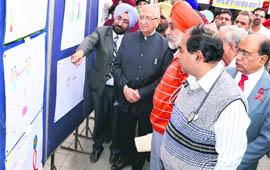 Punjab Minister for Health and Family Welfare Sat Pal Gosain (in black coat) takes a look at posters during a state-level World AIDS Day function in Ludhiana on Thursday. 