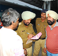 A Government Railway Police (GRP) official issues a challan to a person for violating the ban on smoking at a public place, at Bathinda railway station on Friday.
