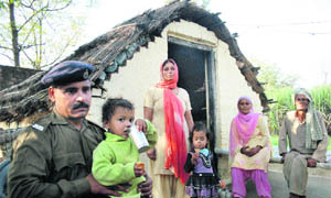 Ramesh Kumar along with members of his family in front of his shanty in Gurah Singhu village on the Akhnoor road. 