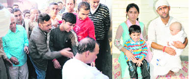 Pranya's father Gautam Dhawan breaks down crying during the burial of his son at Shahkot on Friday; and (below) Pranya in the lap of his father during the 'mundan' ceremony a few days ago. Pranya's mother Ruby Dhawan and his elder brother Jatin also seen in the picture