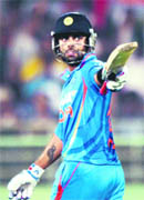 Virat Kohli raises his bat to celebrate his century