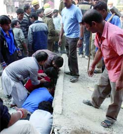 The Delhi policemen and local people remove debris as they search for victims in the rubble of a collapsed building in Uttam Nagar, New Delhi, on Saturday