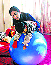 A physiotherapist treats a special child at a community hall in Shimla on Saturday.