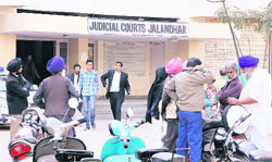 Litgants wait outside the judicial courts in Jalandhar on Saturday. 