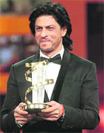 Bollywood star Shah Rukh Khan poses with the tribute he received for his career during the opening ceremony of the 11th Marrakech International Film Festival (FIFM).