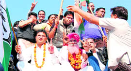 Ashok Tanwar, MP (left), and Congress candidate Jarnail Singh flash the victory sign during a procession in Ratia on Sunday.