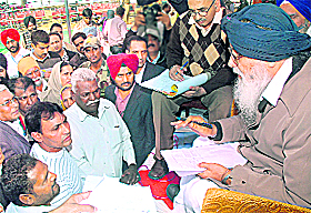 Chief Minister Parkash Singh Badal listens to grievances of people during his Sangat Darshan at Aladinpur village in Jalandhar Cantt on Sunday.