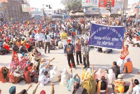 Members of the Unemployed Linemen Union, Punjab, along with their family members staged a blockade at the traffic light chowk in front of the bus stand in Bathinda on Monday