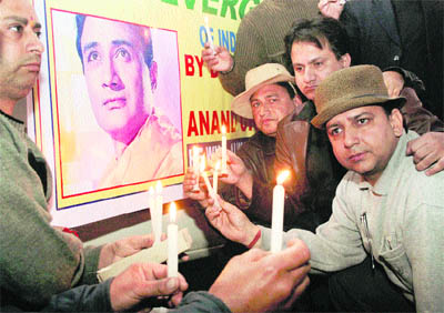 Fans light candles in memory of Bollywood legend Dev Anand in Jammu on Monday.